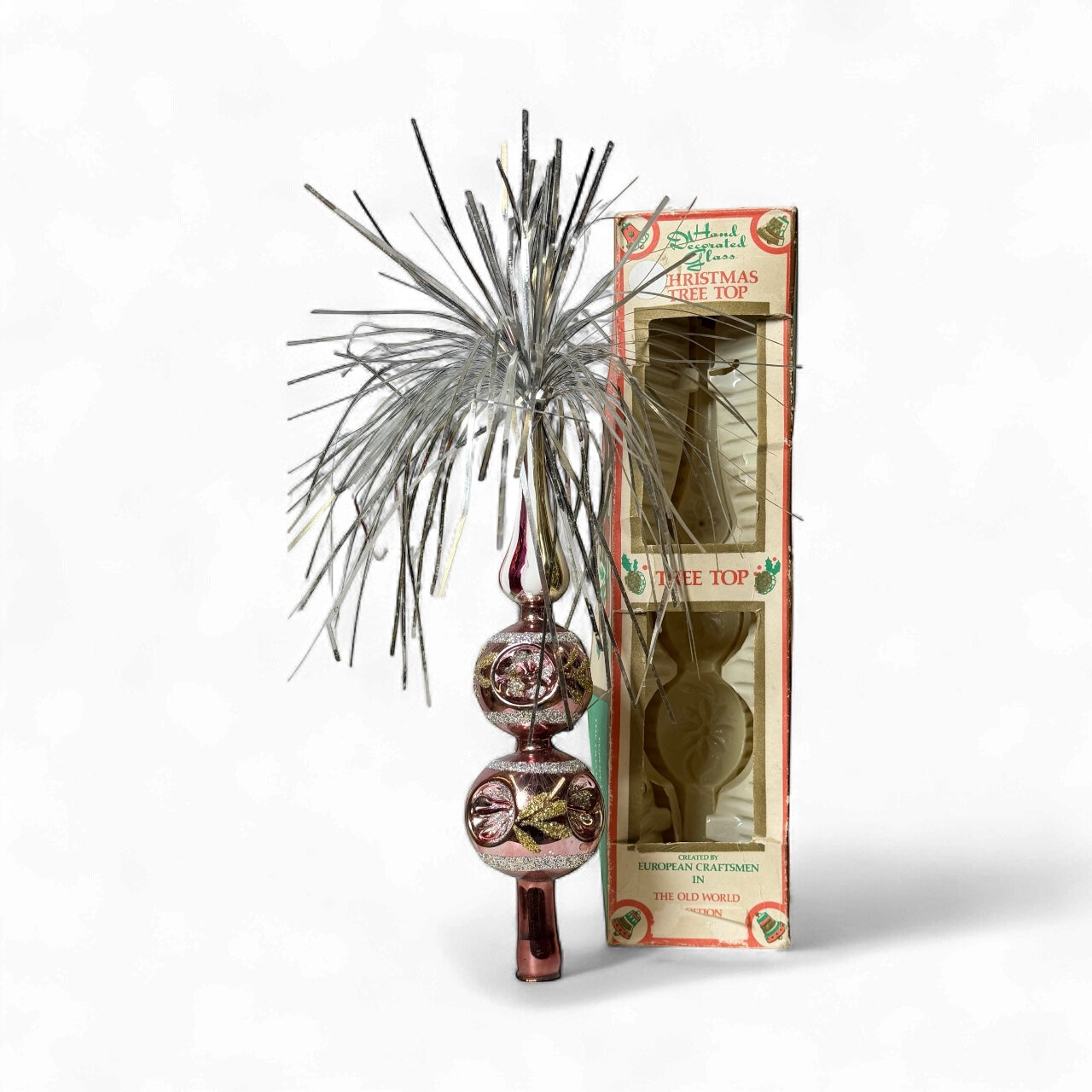 Vintage hand decorated glass Christmas tree topper with pink finish, gold detailing, and silver tinsel burst, displayed with original Commodore box