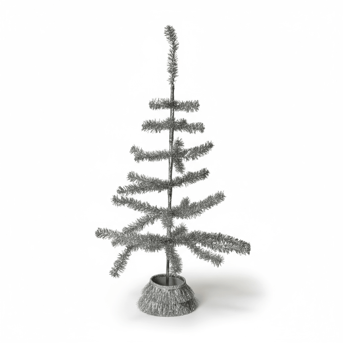 Vintage silver tabletop tinsel tree with tiered branches and removable circular skirt
