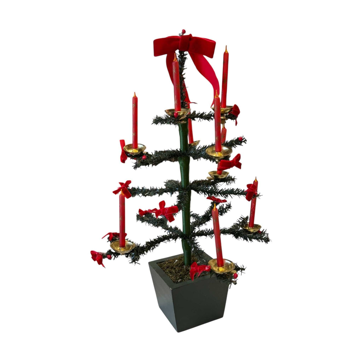 
                  
                    Vintage little green Christmas tree with red glass candle ornaments and red bows on a wooden base
                  
                