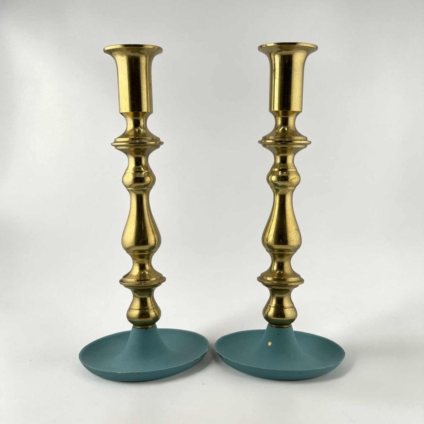 Pair of vintage brass candlesticks with teal painted bases and warm patina finish