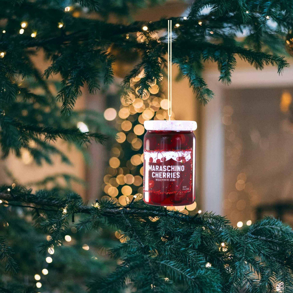 
                  
                    Maraschino Cherries Ornament glass jar with cherries hanging on Christmas tree branch in holiday decor
                  
                