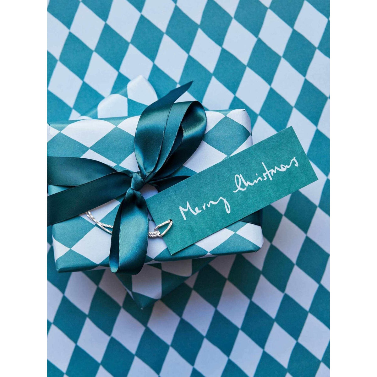 
                  
                    Set of 8 teal Merry Christmas gift tags on FSC-certified card tied to wrapped present with teal ribbon
                  
                