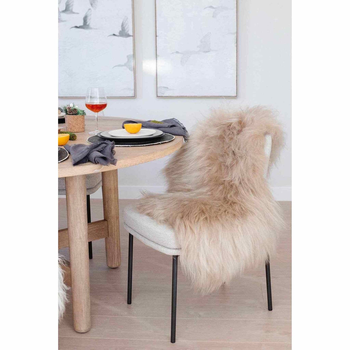 Nude Icelandic sheepskin throw rug draped over chair in dining room setting