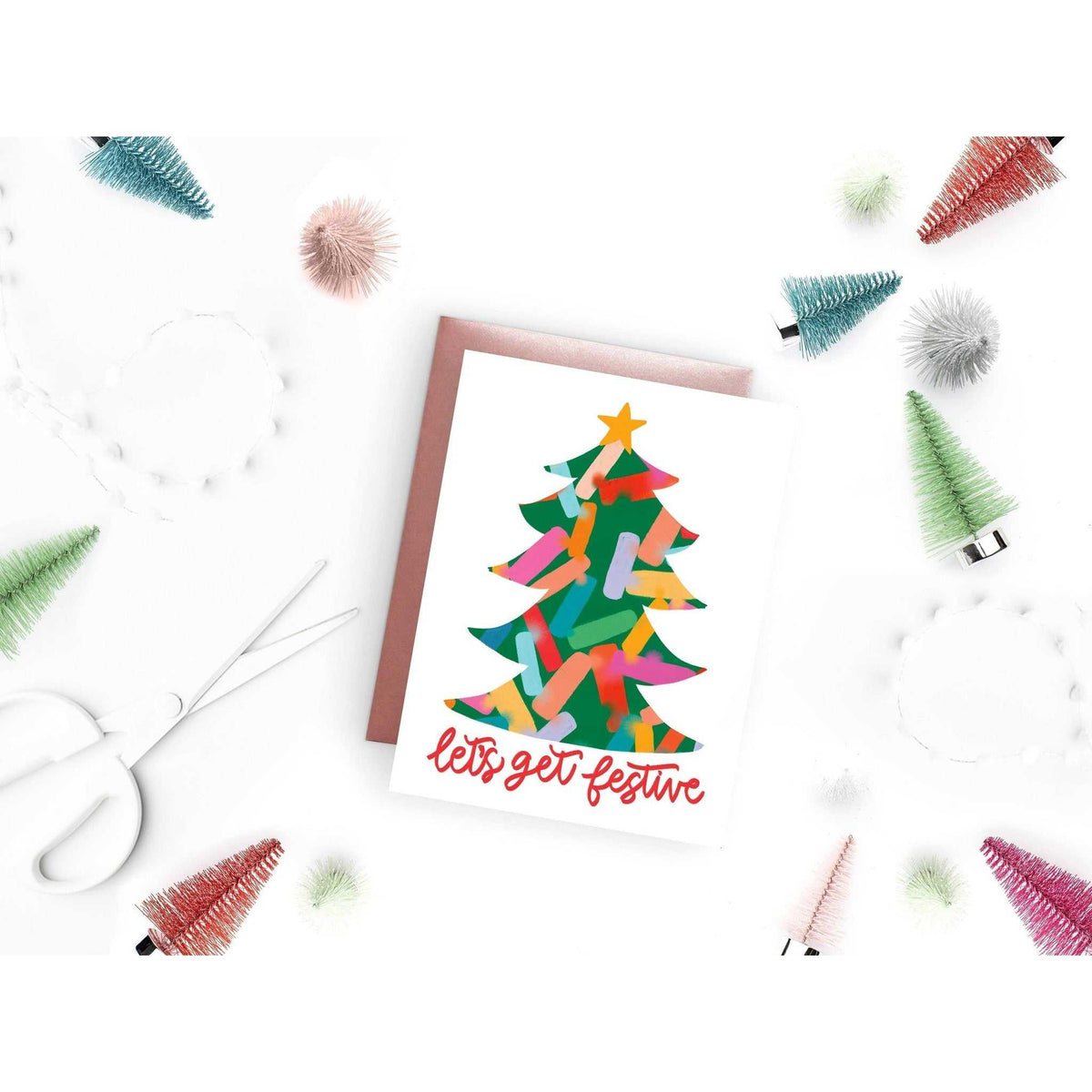
                  
                    Festive Tree Card with colorful Christmas tree design and "let's get festive" text, A2 size holiday greeting card with pink envelope.
                  
                