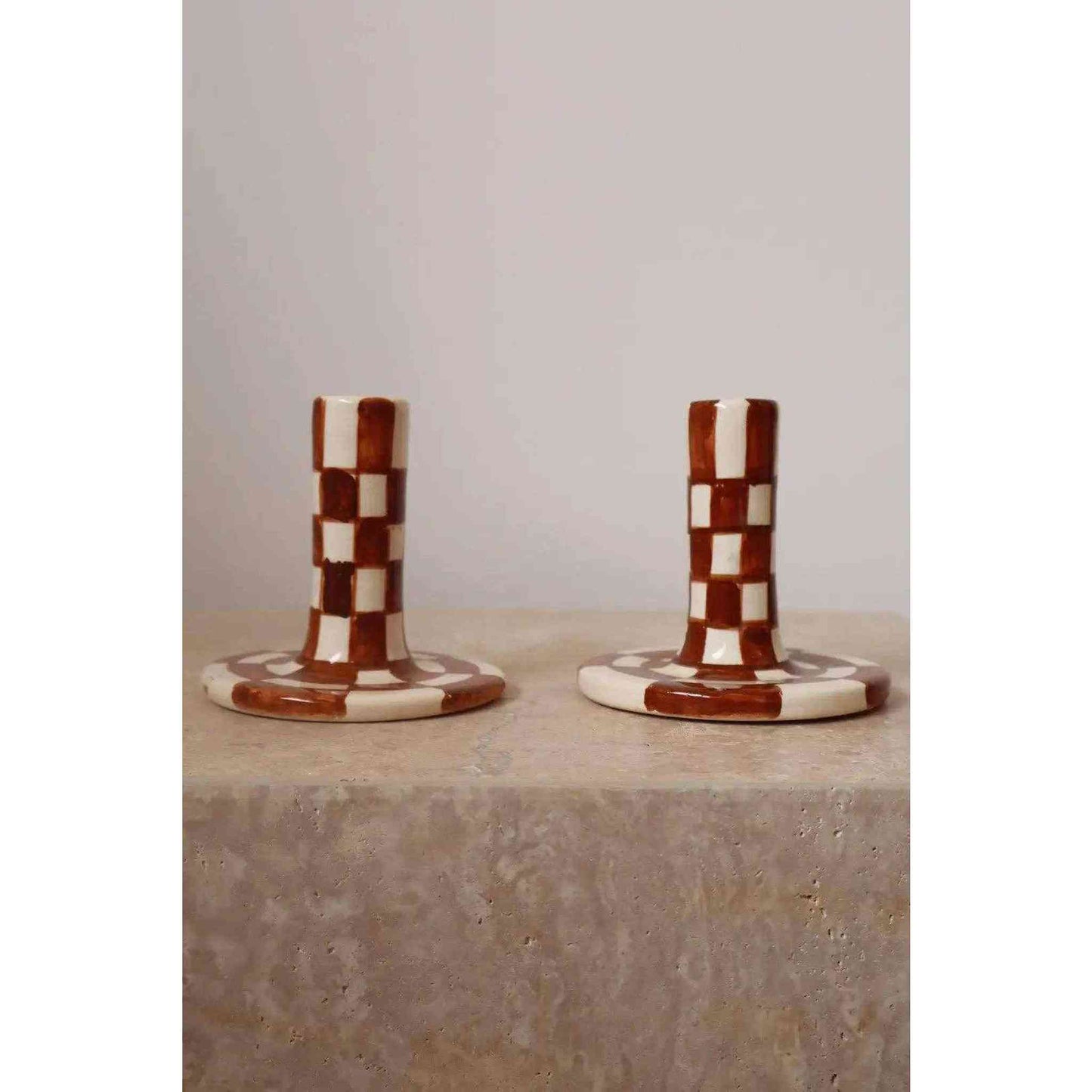 Pair of handmade brown and white checkered ceramic candle holders with a modern glaze finish