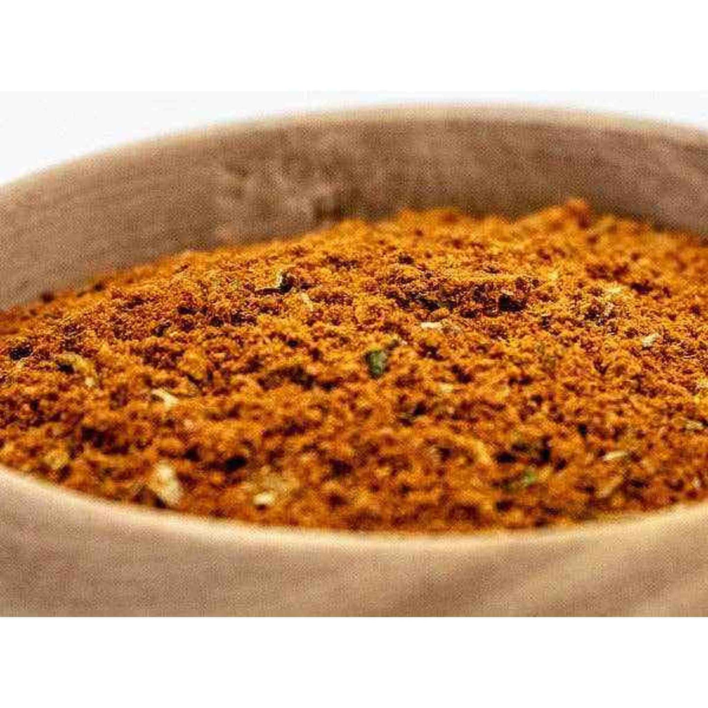 Close-up of BBQ Mix seasoning blend with paprika, cinnamon, turmeric, garlic, and herbs in a wooden bowl