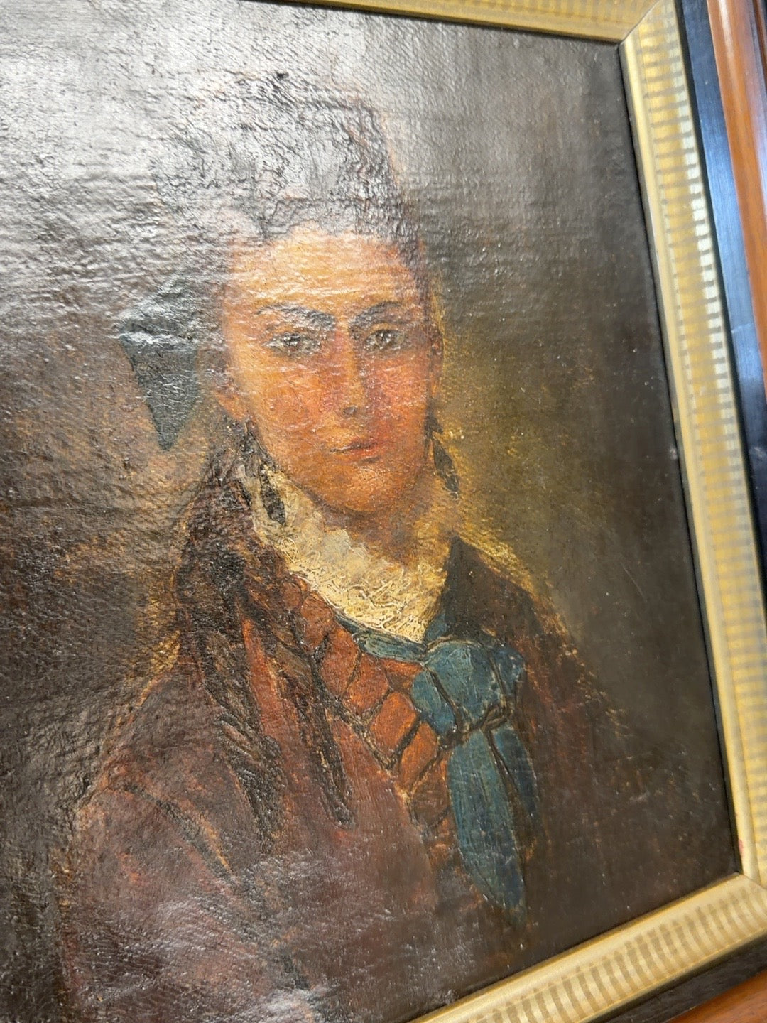 
                  
                    Detailed angled view of antique woman portrait showing oil paint texture and gilt liner
                  
                