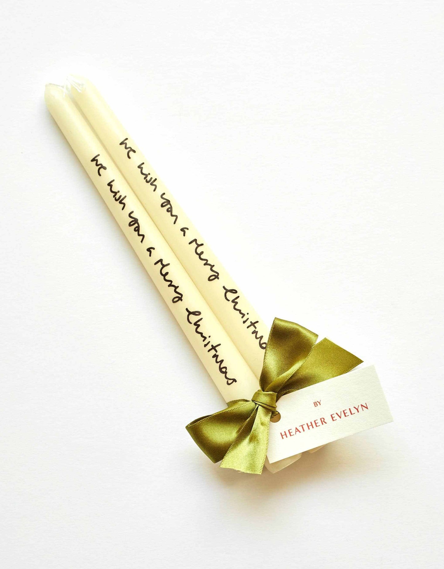 Pair of cream Christmas candles tied with green ribbon and printed with festive message