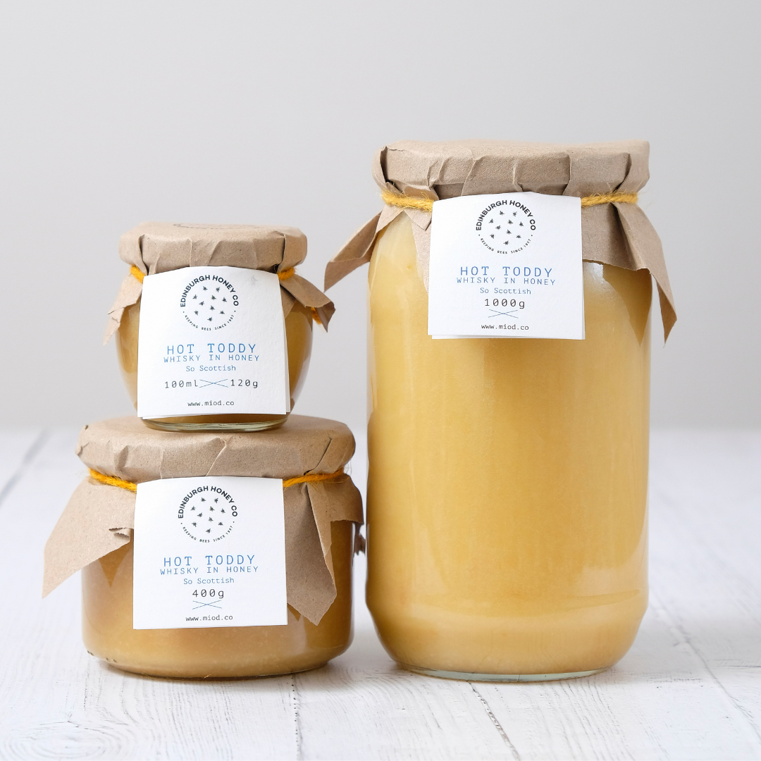 Hot Toddy Whisky Infused Honey jars in various sizes with natural paper lids and labels from Edinburgh Honey Co.