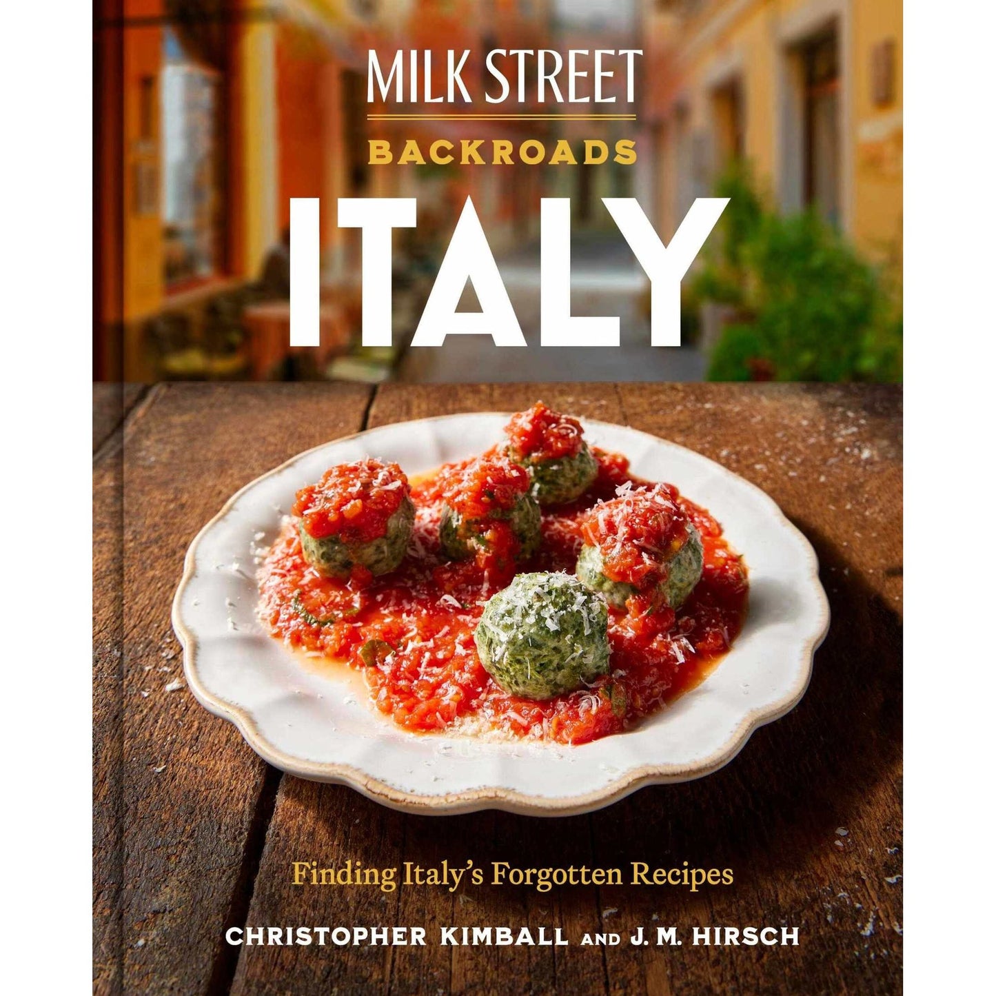 Milk Street Backroads Italy cookbook cover with Italian meatballs in tomato sauce on wooden table