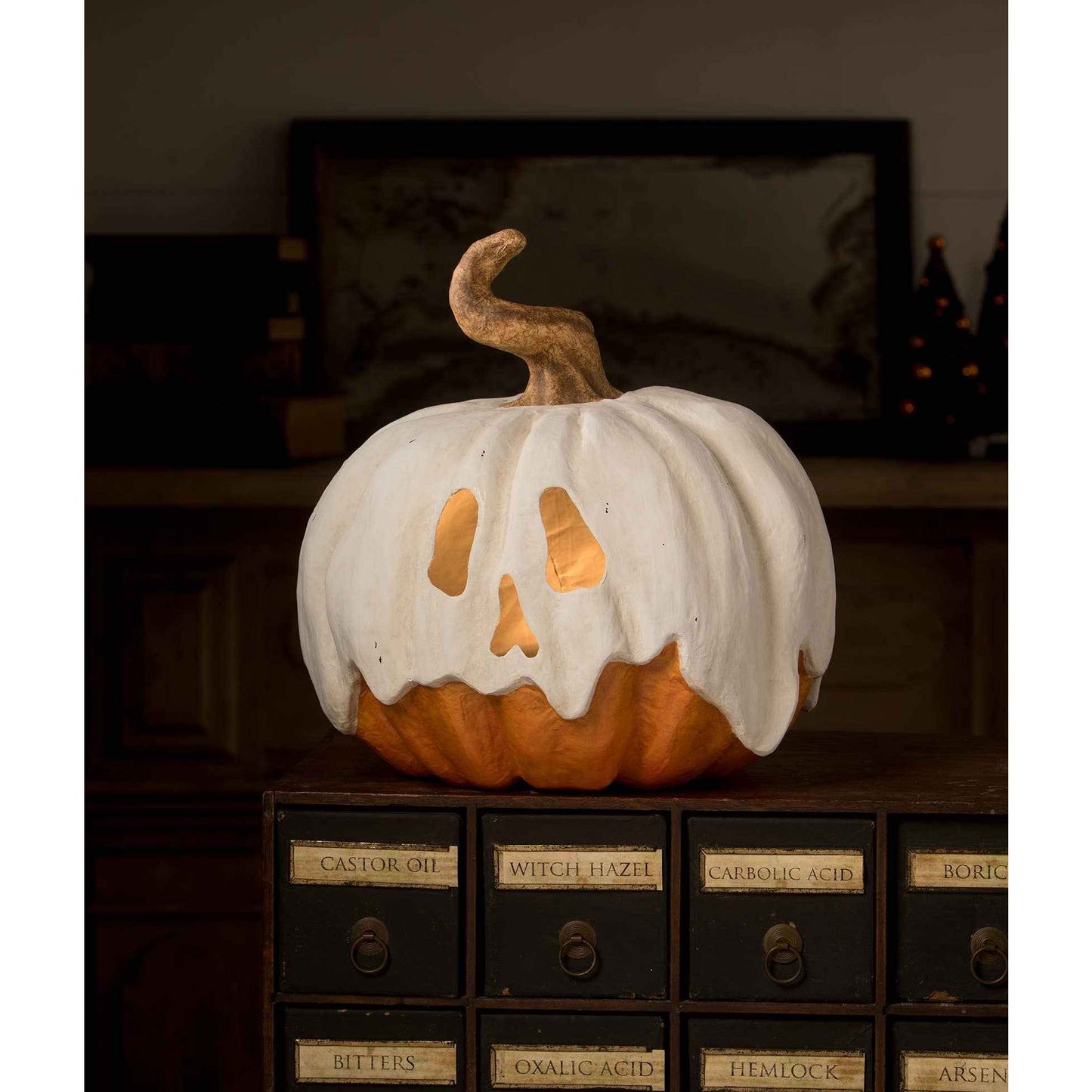 Ghost Jack Paper Mache pumpkin with white ghostly drapery and cut-out face sitting on vintage drawers