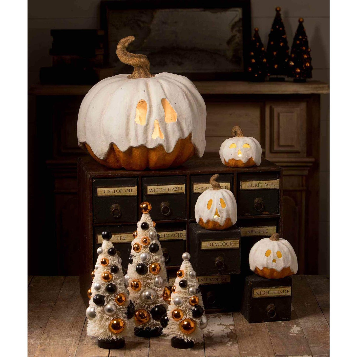 
                  
                    Large Ghost Jack Paper Mache pumpkin with cut-out eyes and nose glowing softly, surrounded by smaller ghost jack pumpkins and decorative Halloween trees
                  
                