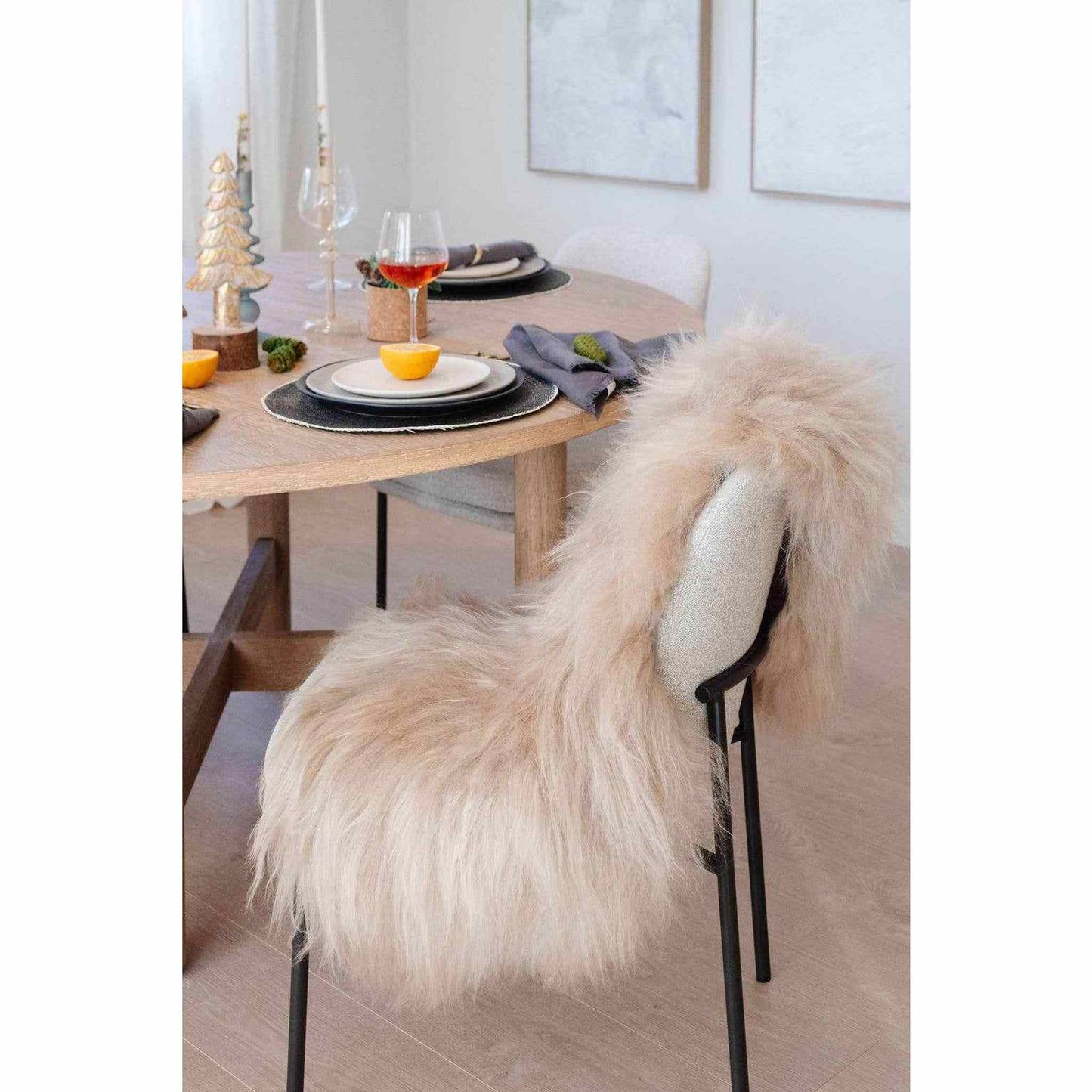 Nude Icelandic sheepskin throw draped over a dining chair with soft, long wool fibers in a beige-grey hue