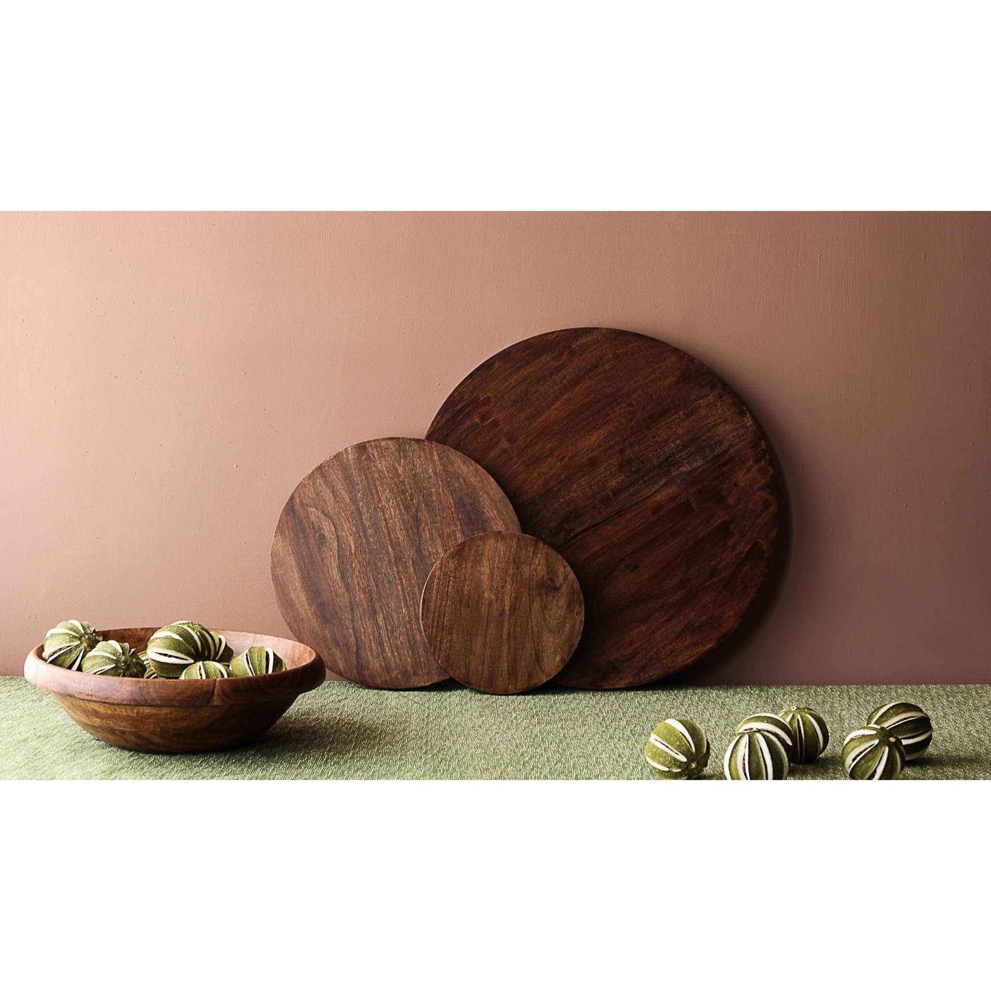 Set of three handcrafted round wooden serving boards in dark mango wood with matte finish showcasing natural grain