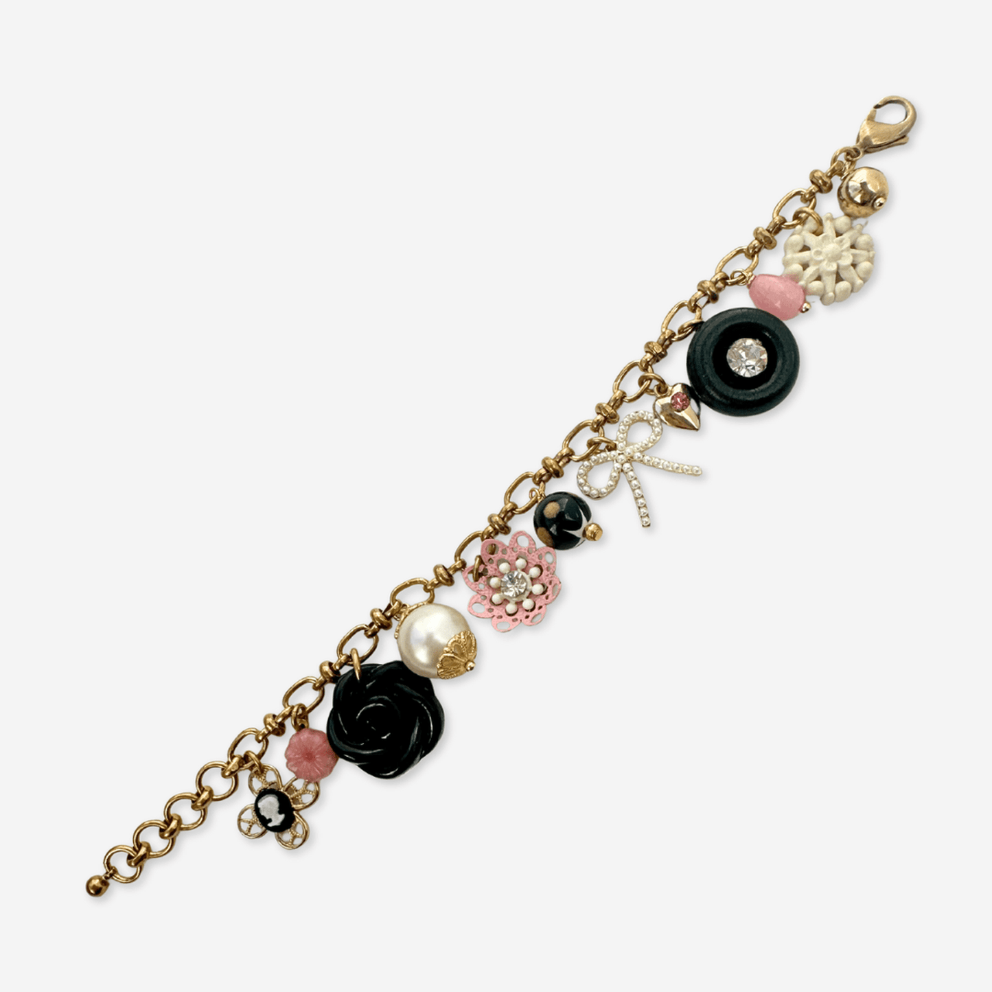 Repurposed vintage charm bracelet with pink, black, and white buttons and beads on adjustable brass chain