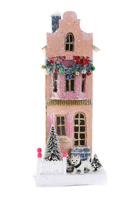 Pink Townhouse Christmas decoration with snow, wreath, and small trees