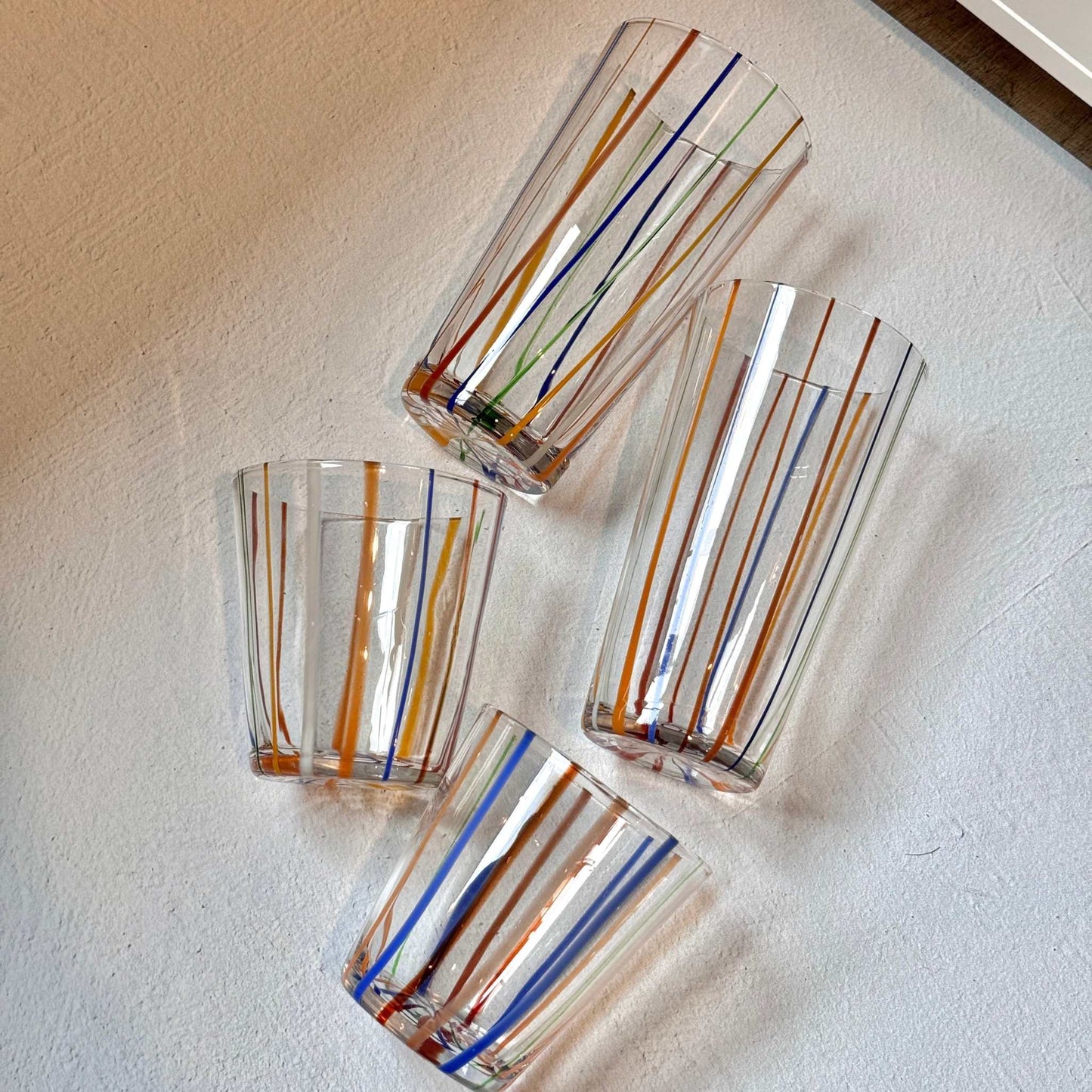 
                  
                    Set of 4 vintage Murano style Italian glasses with colorful vertical stripes, includes 2 short and 2 tall glasses
                  
                