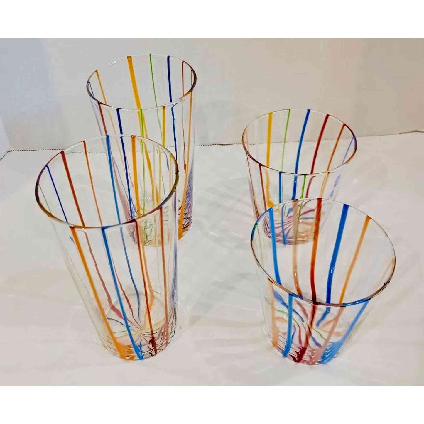 
                  
                    Set of 4 vintage Murano style Italian glasses with colorful vertical stripes, including two tall and two short glasses
                  
                