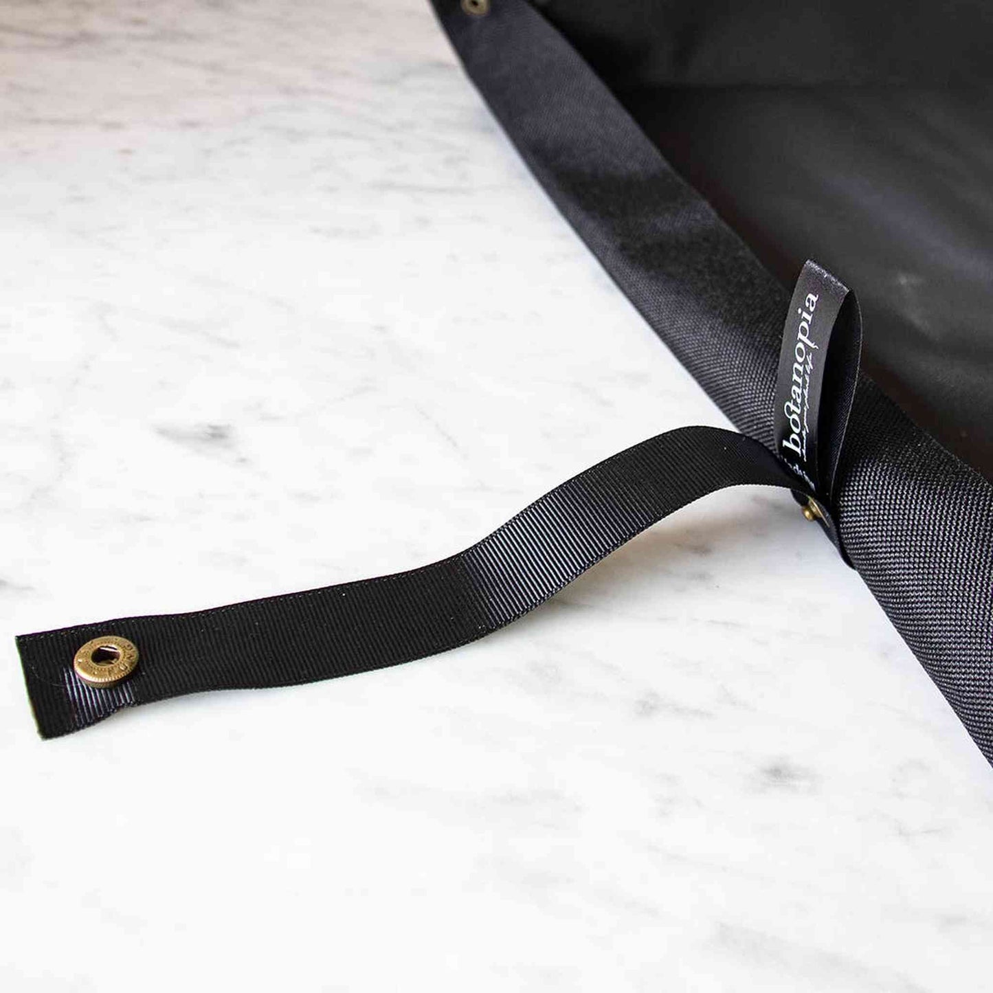 Black vegan potting tarp for clean indoor urban gardening, waterproof and machine washable