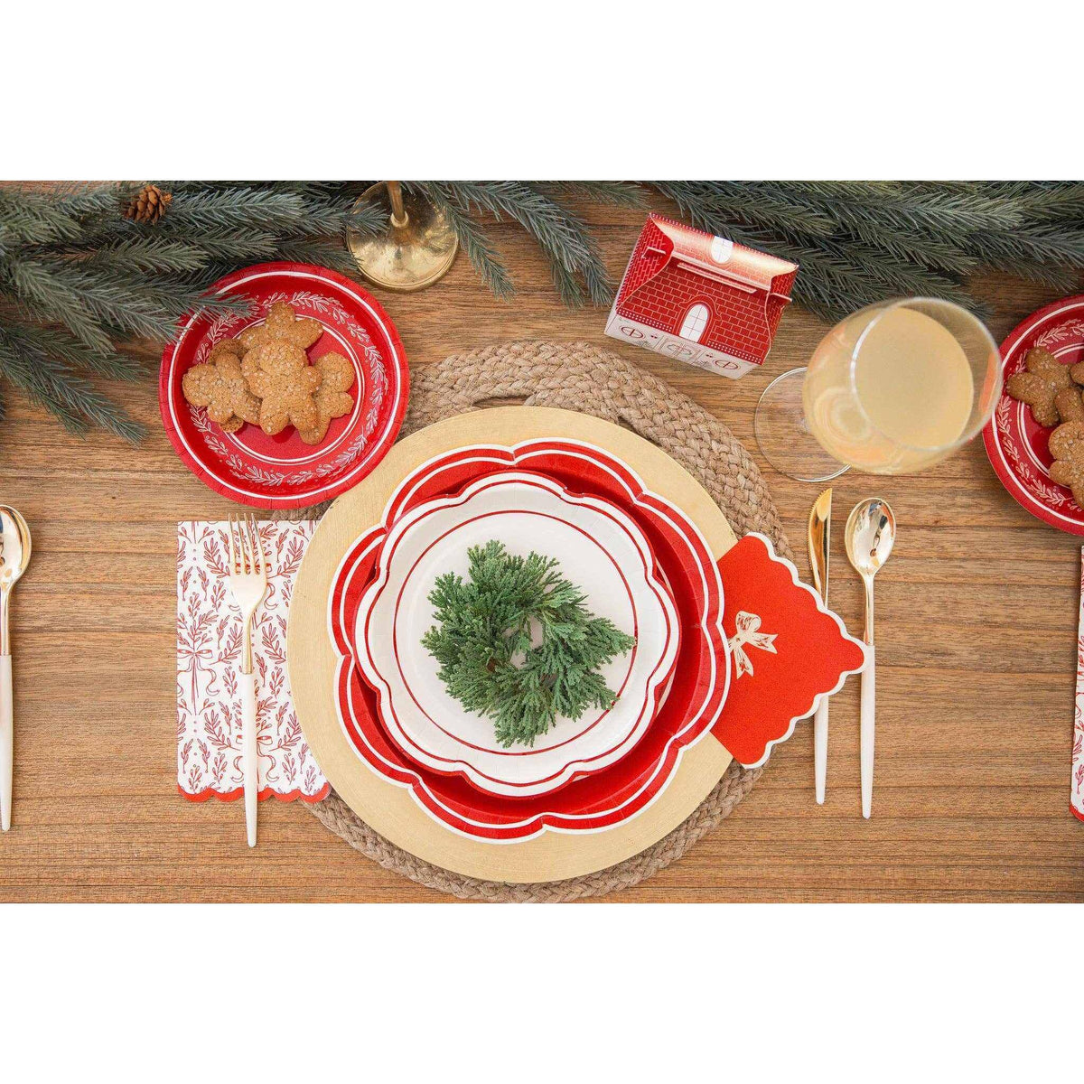 
                  
                    Festive table setting with red and gold bow cocktail napkins featuring gold-foil accents on a holiday-themed spread
                  
                
