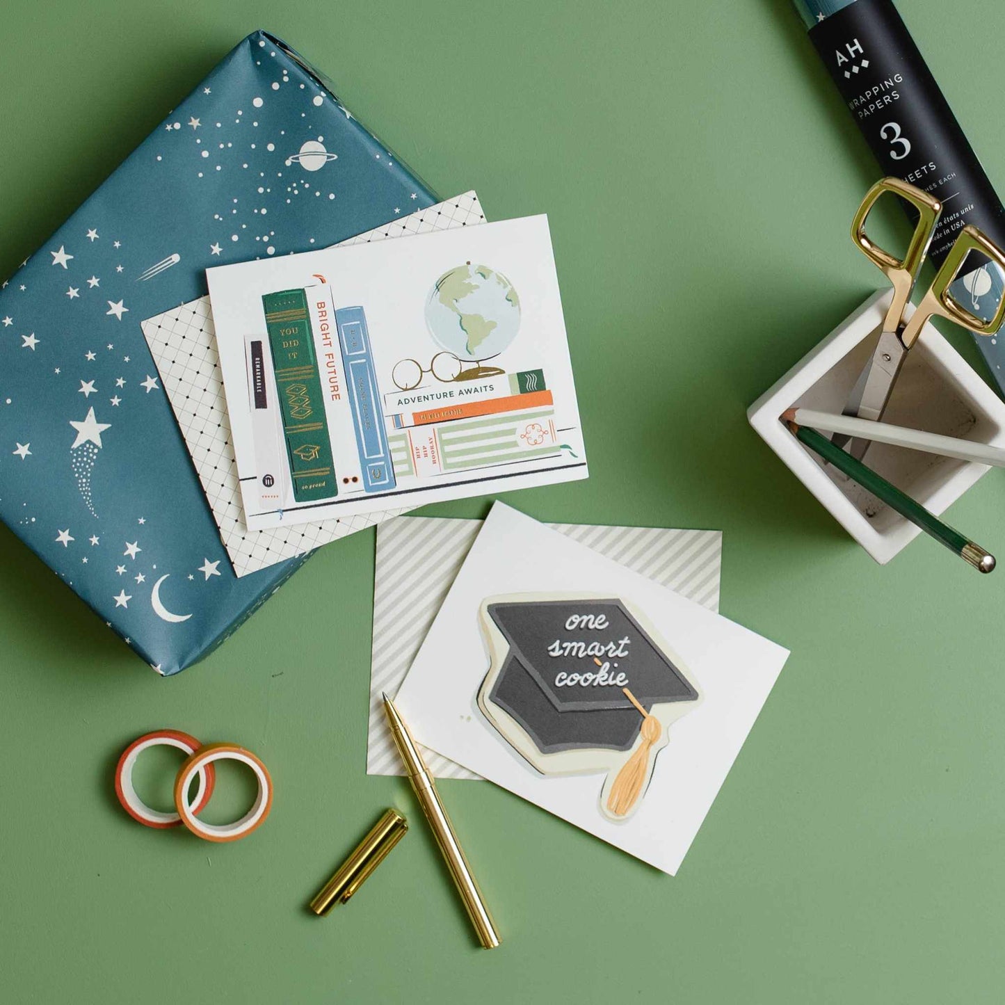 Elegant graduation card featuring book-themed design with gold foil and coordinating envelope on green background