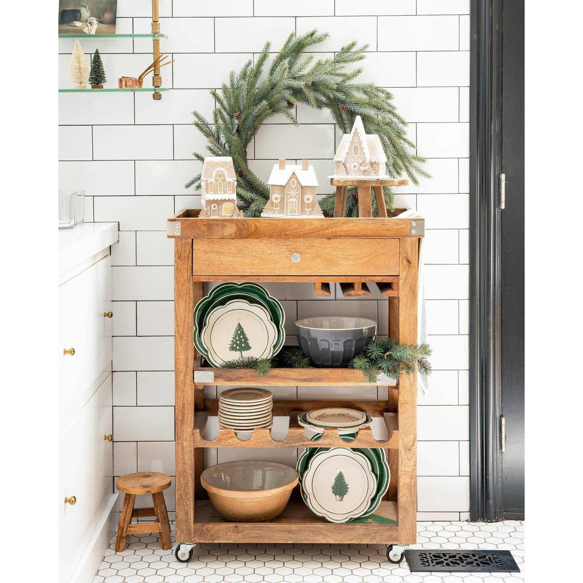 
                  
                    Festive gingerbread house decoration with light on wooden cart in holiday kitchen setting
                  
                