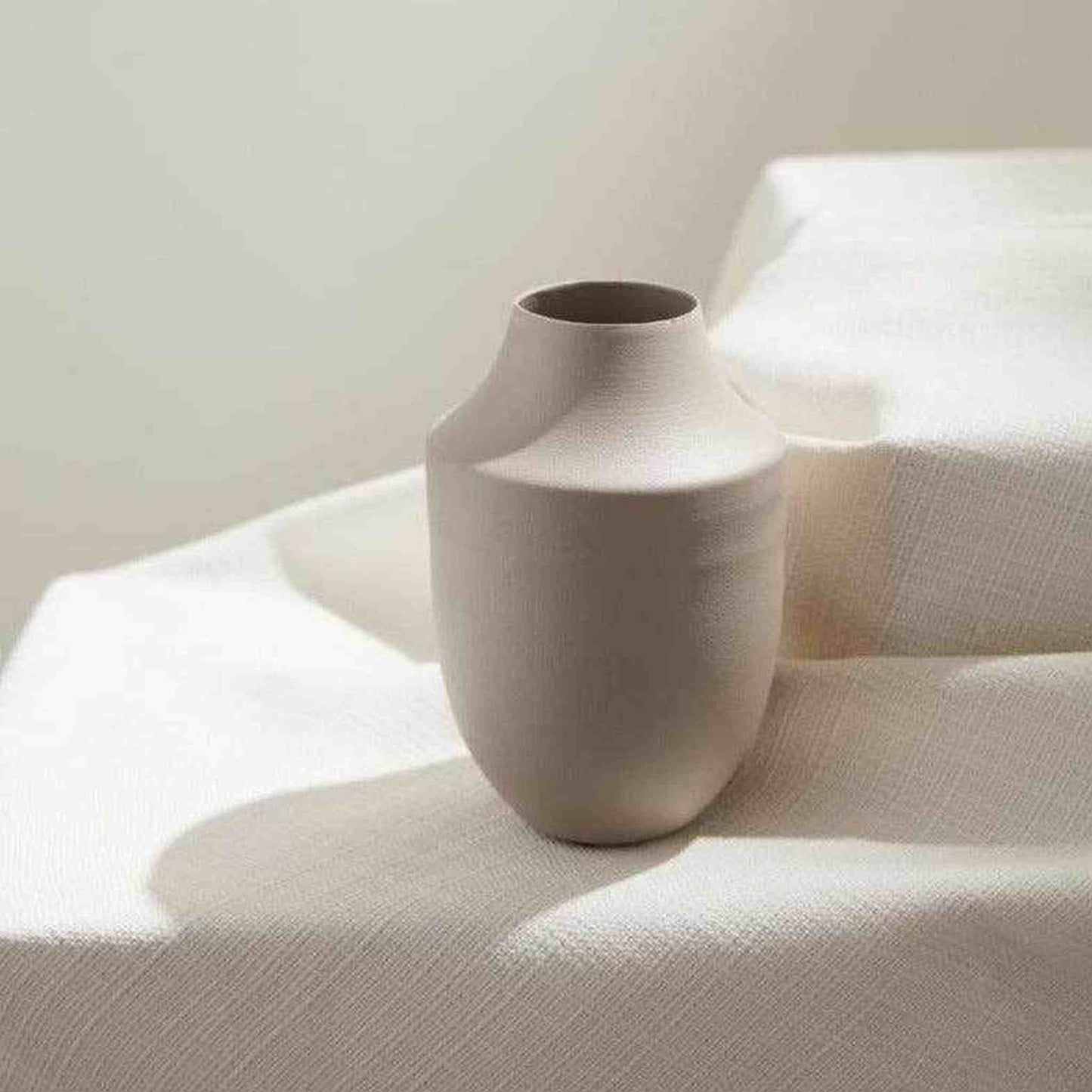 Neutral metal Milan vase for magnolia blossoms arrangement with serene, calming design