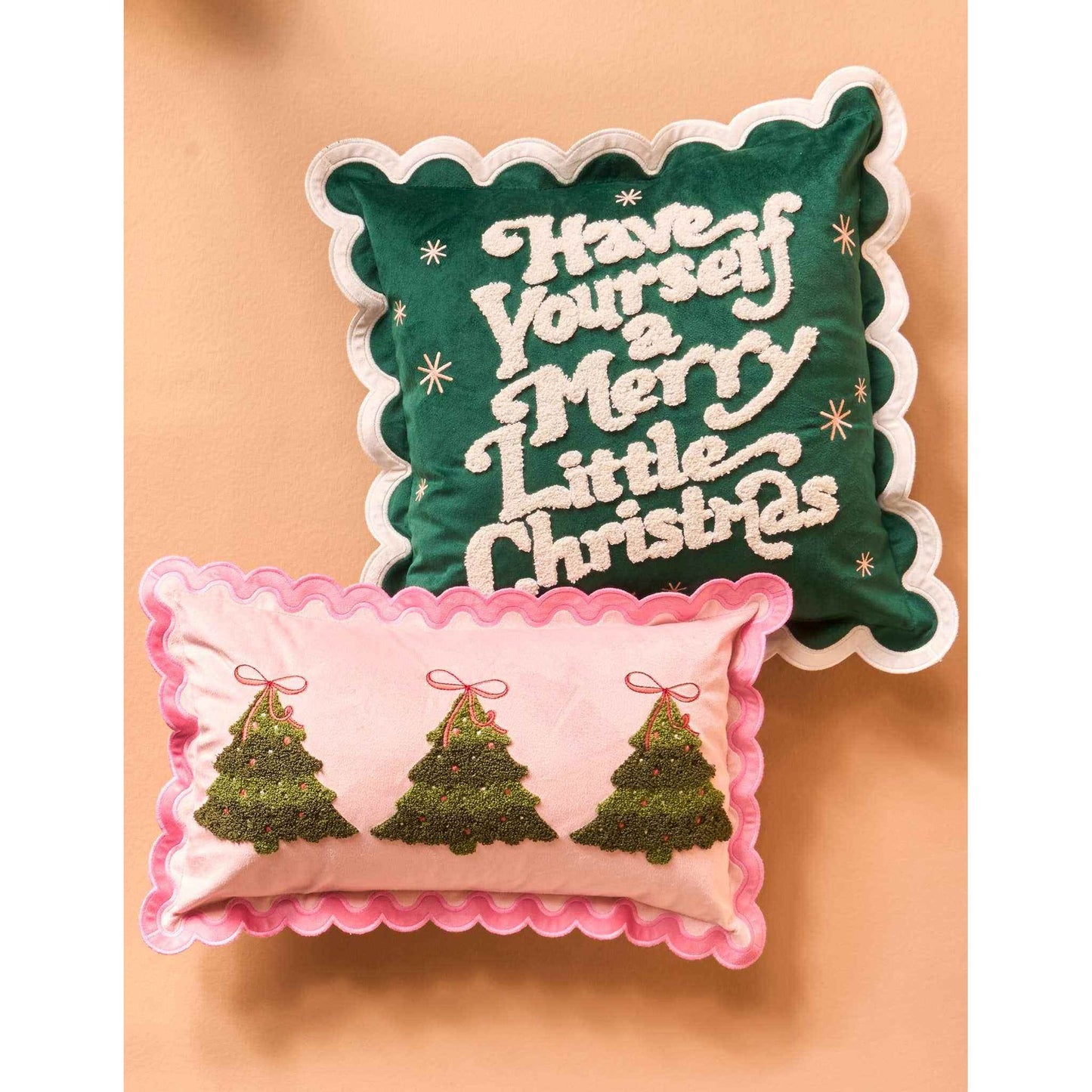 Scalloped square Christmas throw pillow with festive green and pink designs and holiday messages