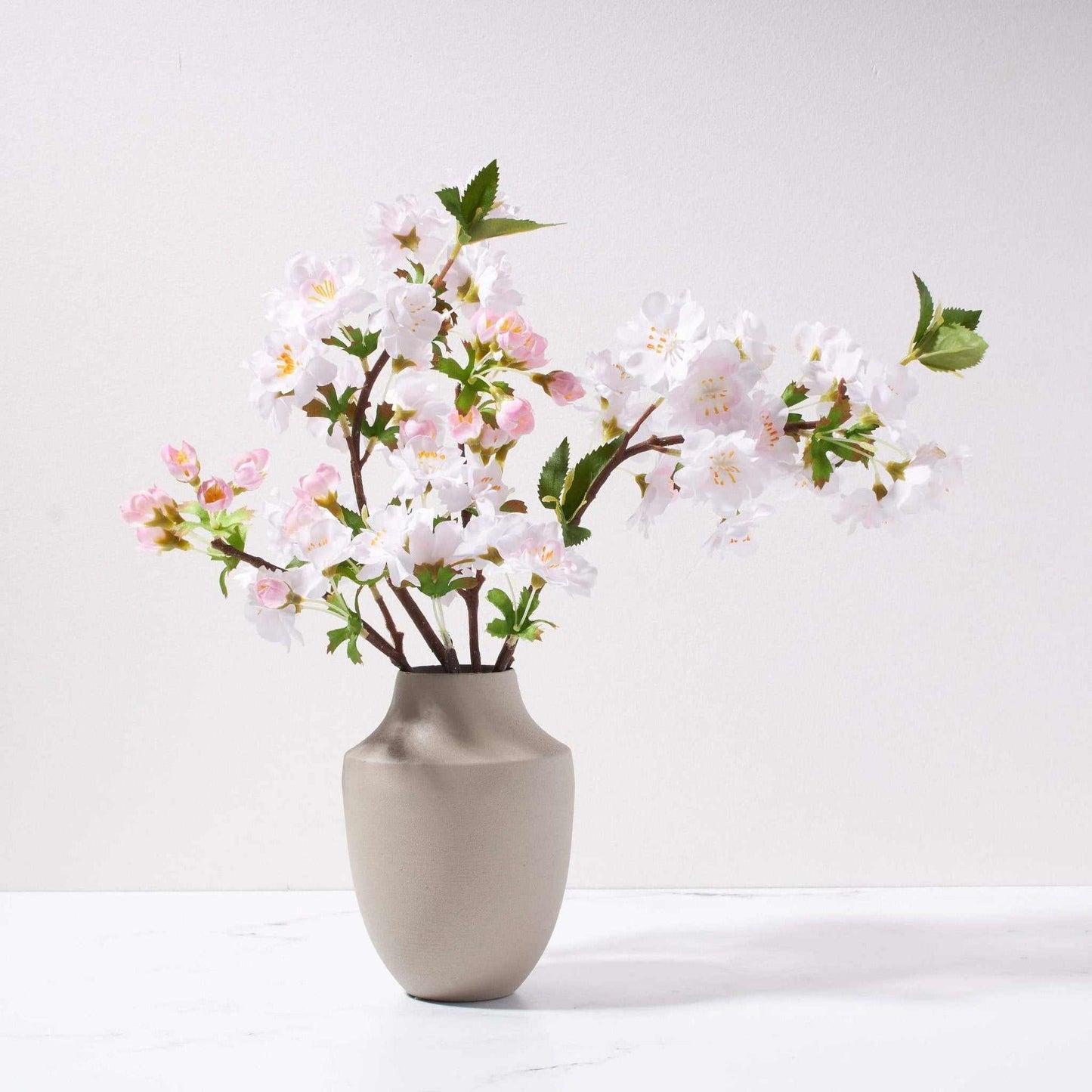 Petite Cherry Blossom in Milan vase with springy pink budding branches in sleek metal vase