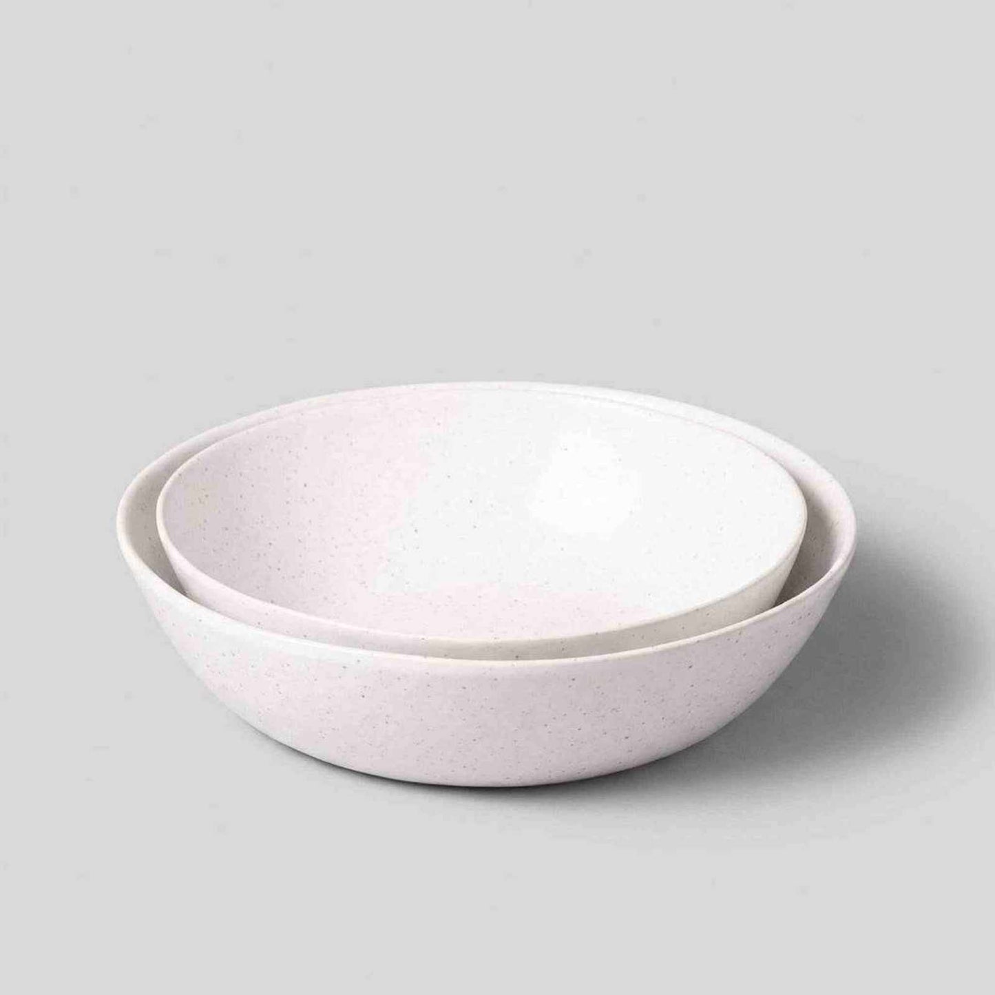 Set of two hand-finished speckled white low serving bowls made from artisan stoneware in Portugal