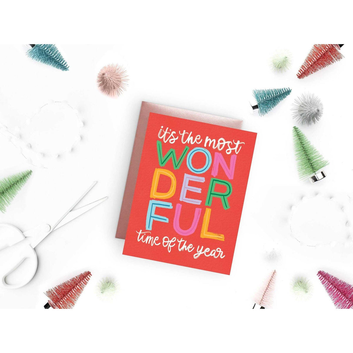 
                  
                    Most Wonderful Time Card holiday greeting card with colorful text and pink A2 envelope surrounded by festive decorations
                  
                