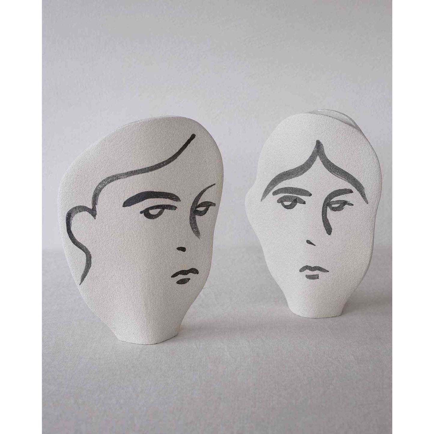 
                  
                    Two handmade ceramic summer vases with minimalist hand-painted human face motifs in white stoneware
                  
                
