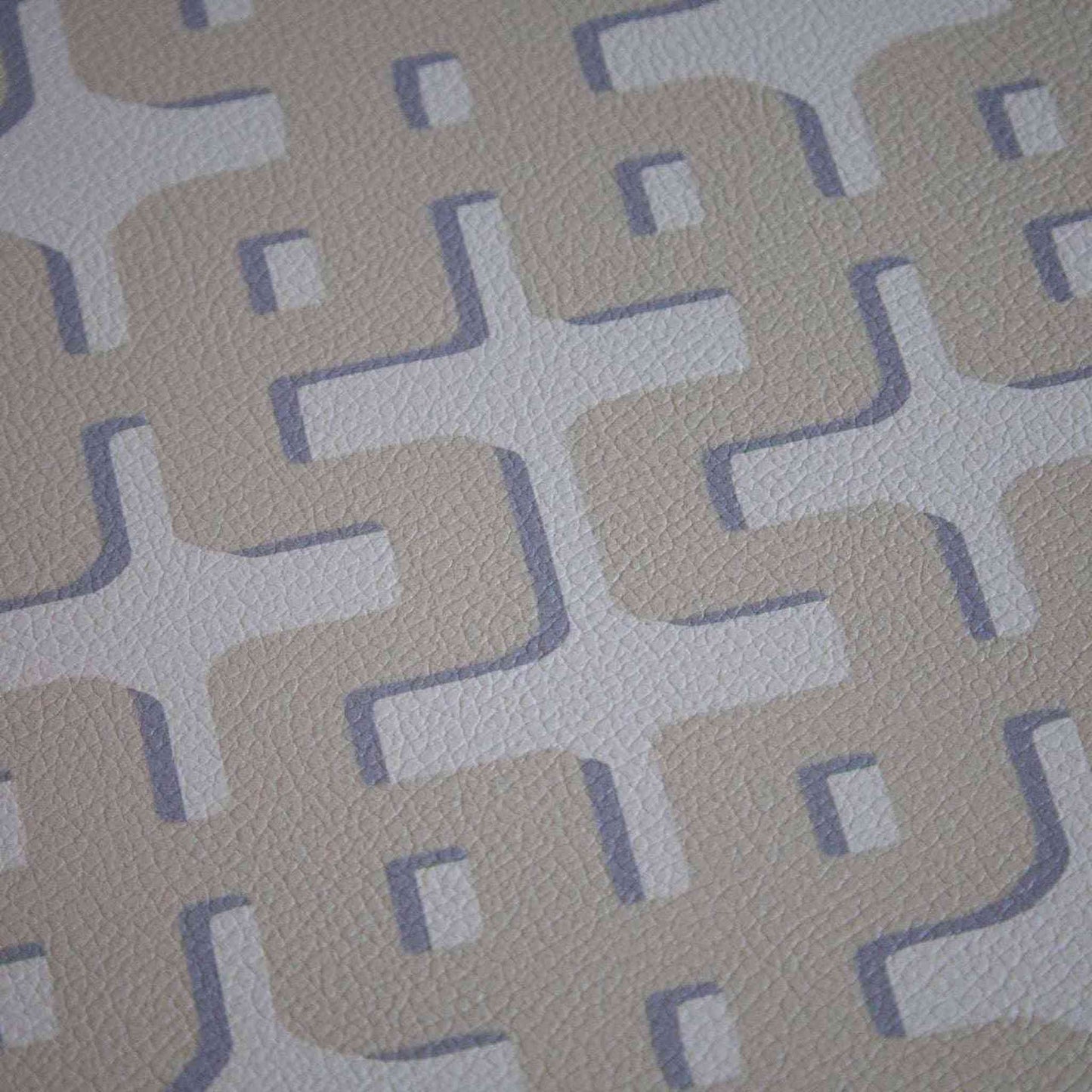 Close-up of Pebble Round Placemat with beige and light gray geometric pattern and textured surface