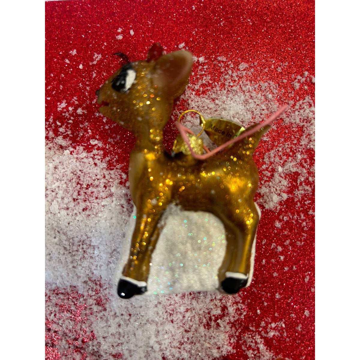 
                  
                    Vintage-style Retro Rudolph Ornament with matte-glitter finish on red and white background
                  
                
