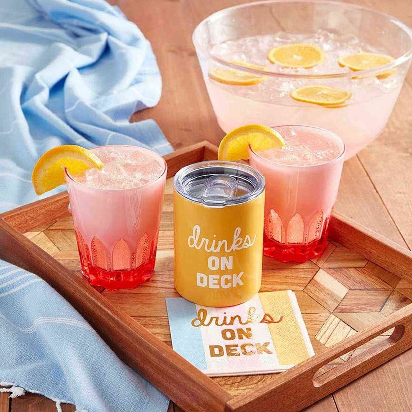 Pink double face acrylic tumbler with pink drink and lemon garnish on wooden tray for outdoor entertaining